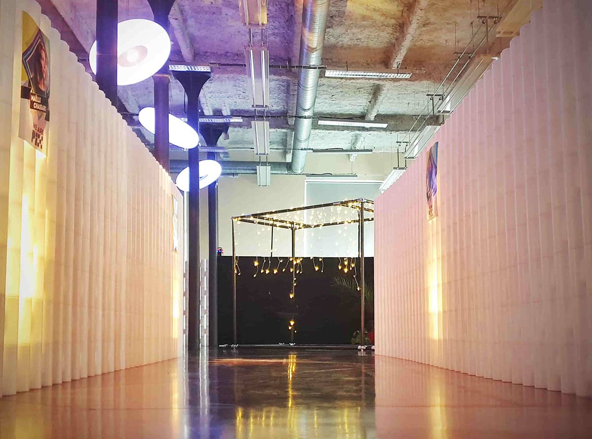 Two freestanding modular partition walls forming a lit walkway at an event