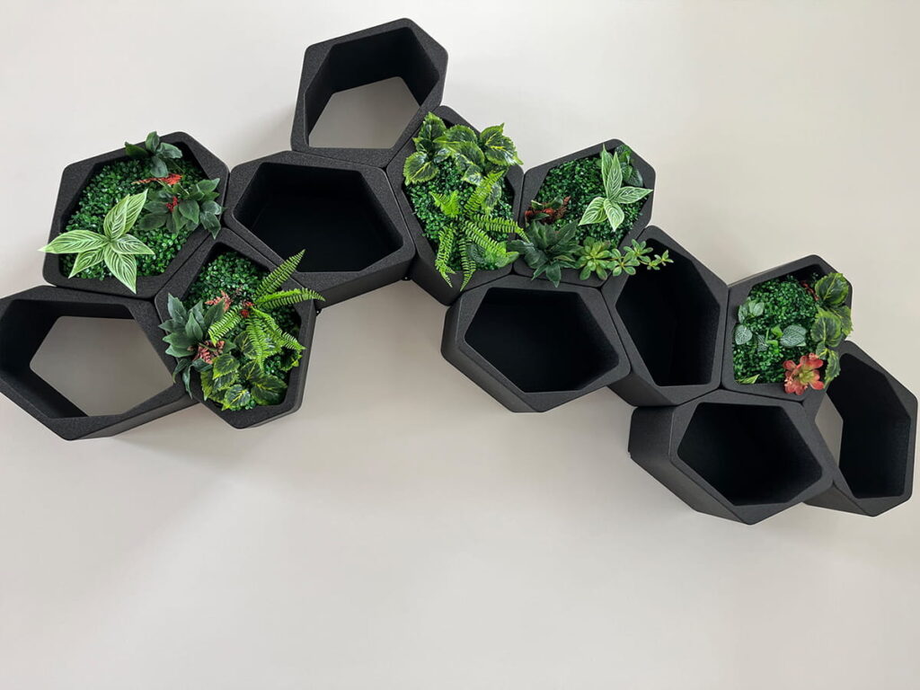 Black BUILD hexagon shelves made from recyclable EPP as a modular plant wall