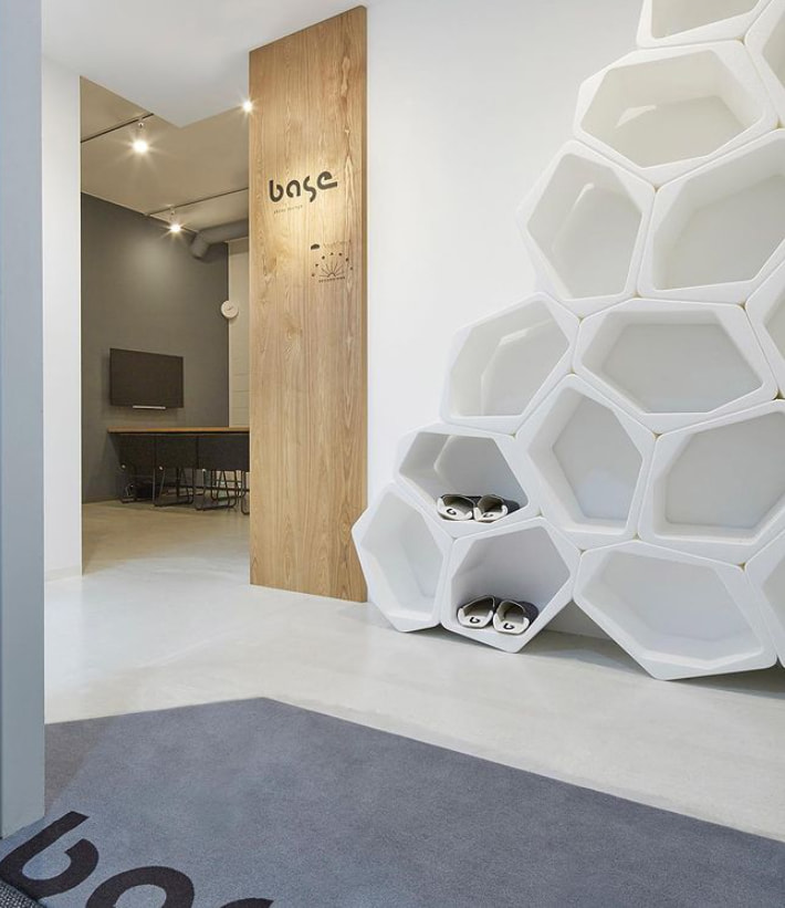 Weißes modulares Wabenregal an der Wand eines Designstudios in Tokio