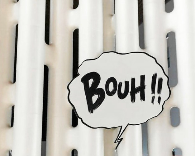 Detail of a white LINK partition wall with a speech bubble sign