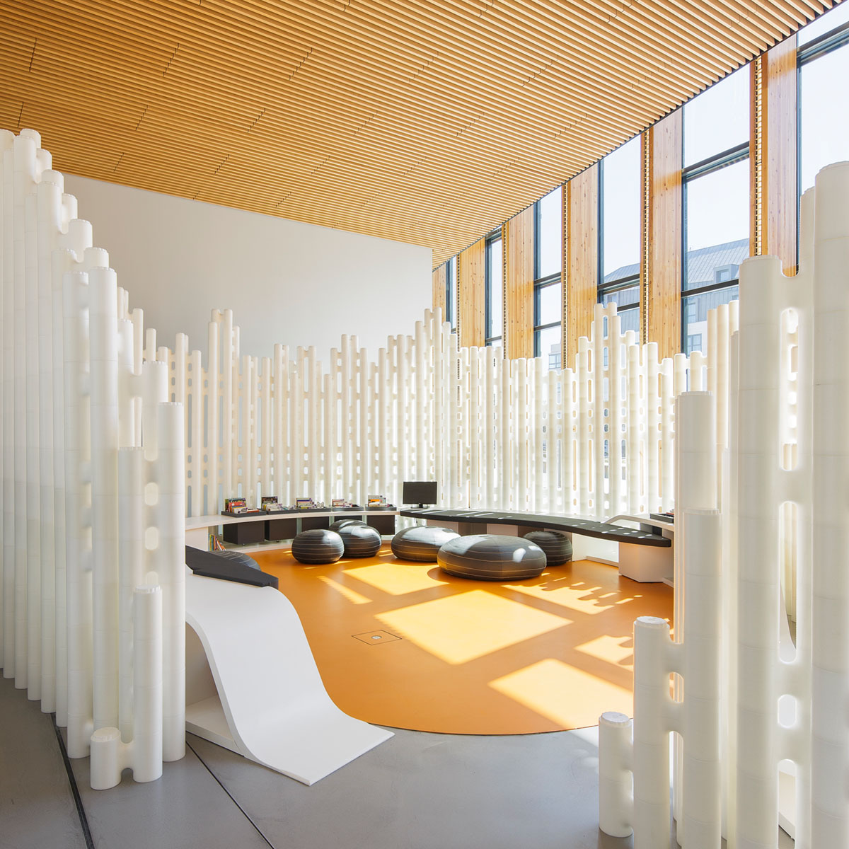 Freestanding modular room divider forming a curved reading zone at Saint-Malo Mediatheque, France