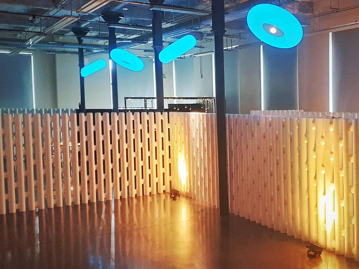 Freestanding white modular partition walls glowing in warm light in an event space