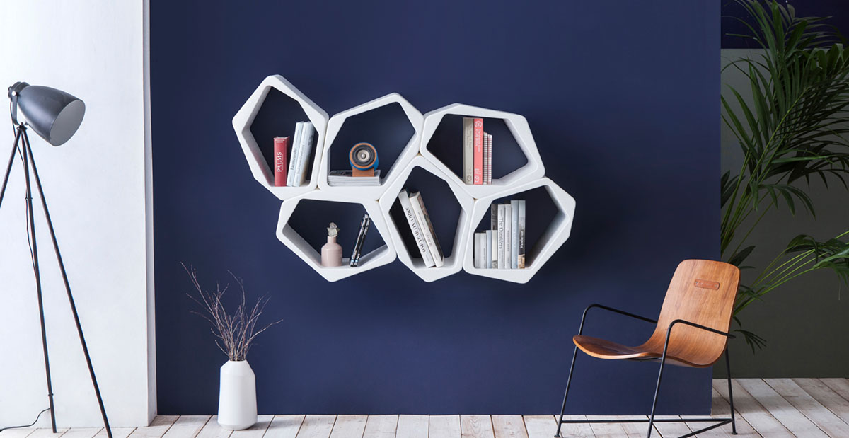 Weiße schwebende Wabenregale auf blauer Wand im Wohnzimmer