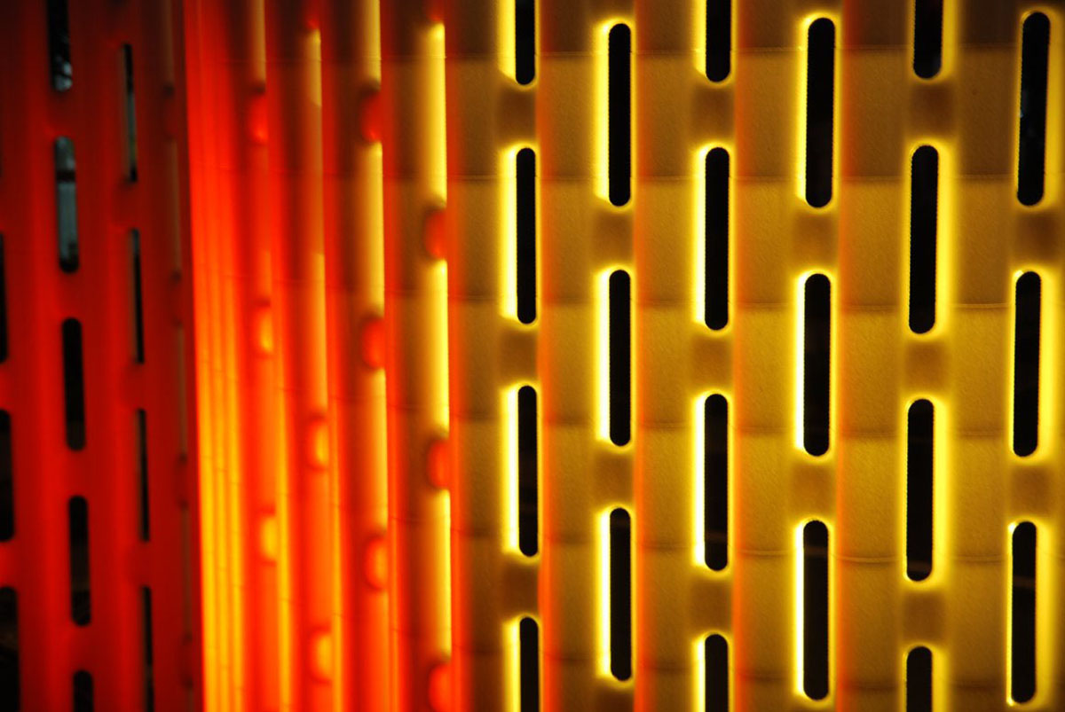Modular partition wall lit from behind, glowing in yellow and red