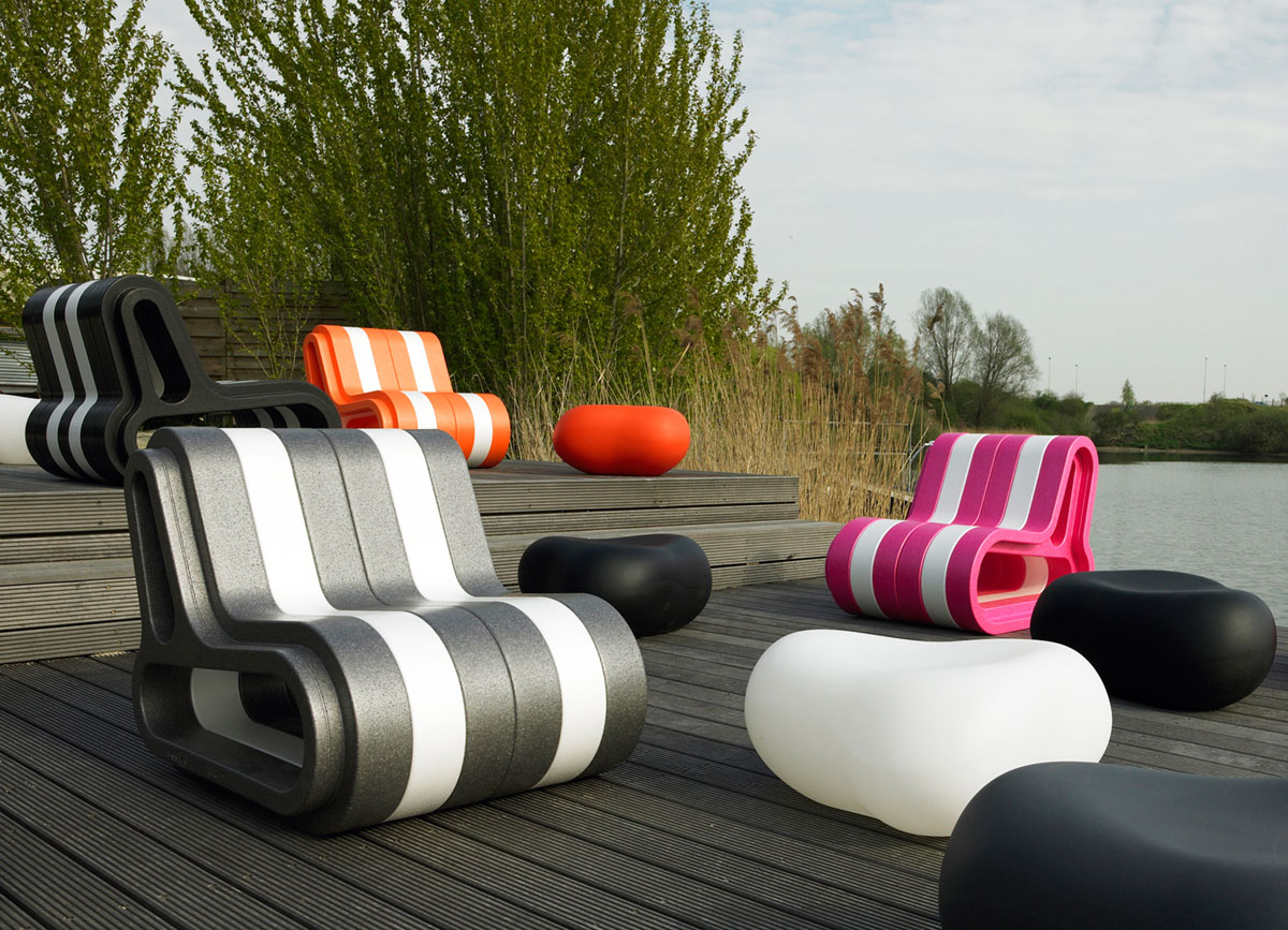 Q-COUCH seats in black, white, pink and orange on a wooden deck by a lake